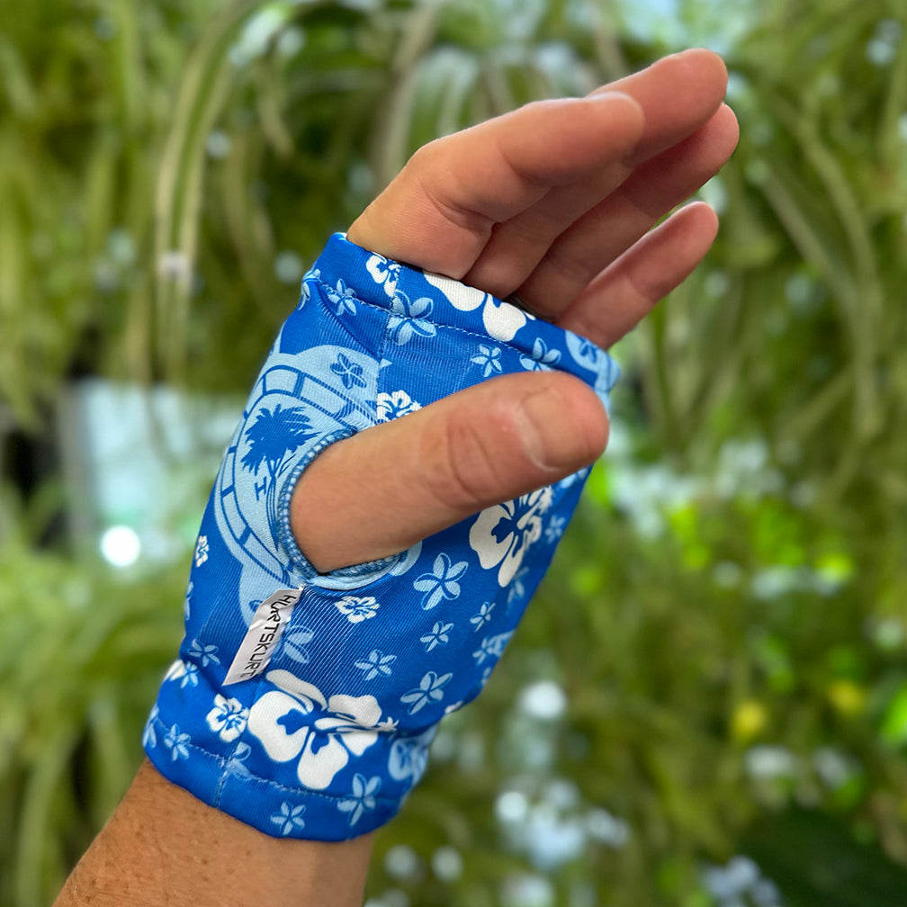 An image of a man wearing HurtSkurt's small blue wearable ice pack for hand and wrist pain relief which has a thumb hole for daily use.