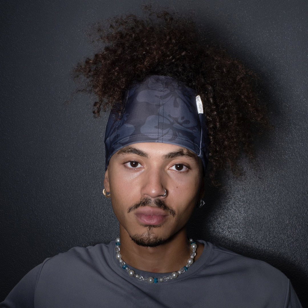 Man wearing a SkullSkurt™ and gray shirt against a dark background