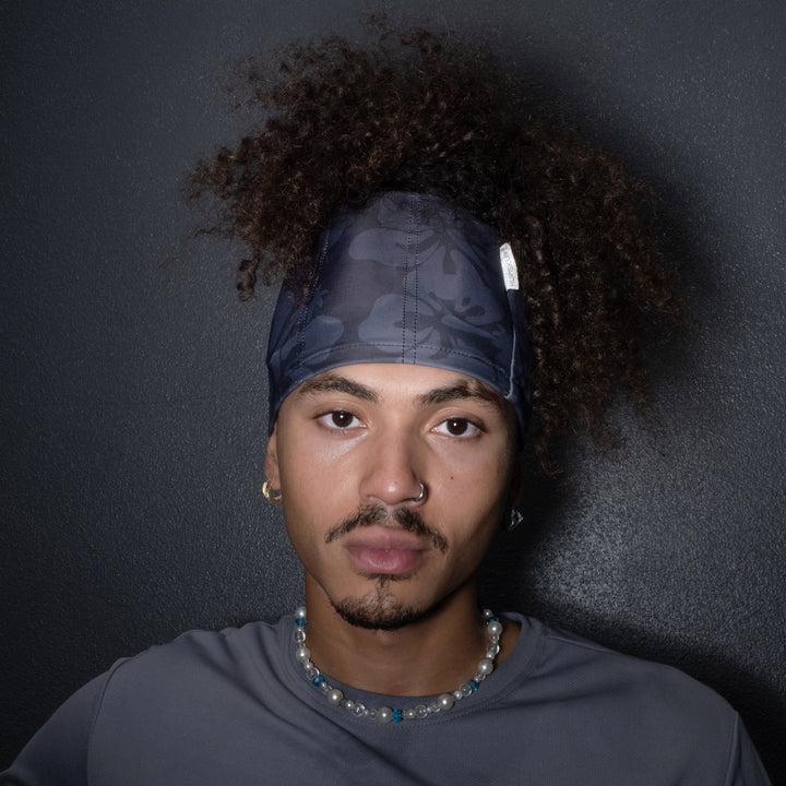 Man wearing a SkullSkurt™ and gray shirt against a dark background