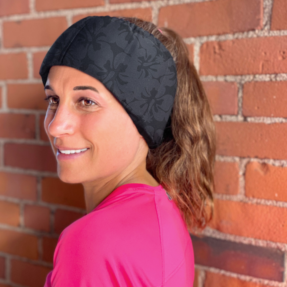 A woman smiling while wearing a HurtSkurt migraine headband for migraine pain relief.