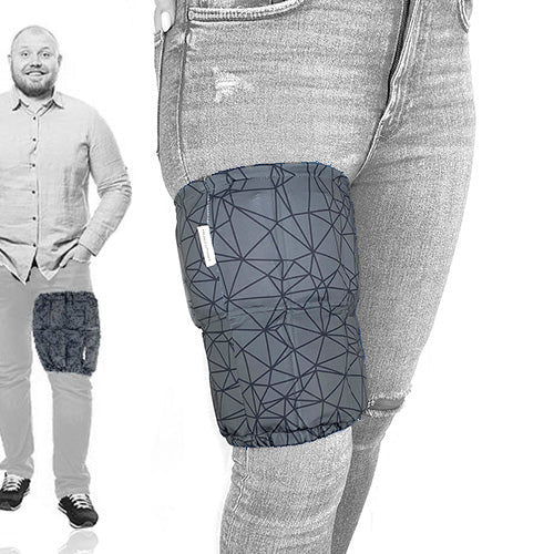 A man wearing a grey extra large ice pack with a geometric pattern around his thigh for pain relief.