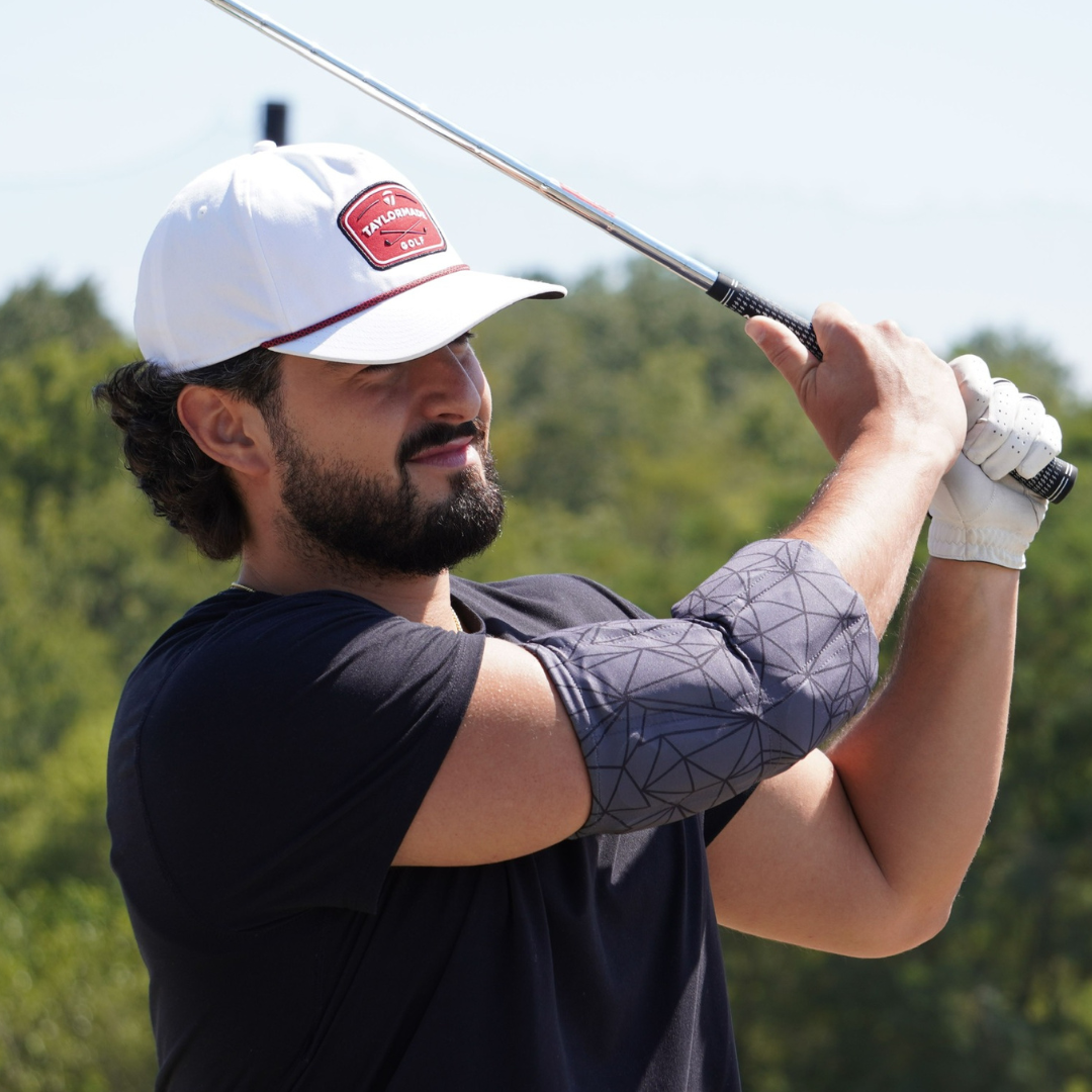Golfer wearing a Medium Blackout HurtSkurt® on his elbow to help alleviate pain associated with Golfer's Elbow
