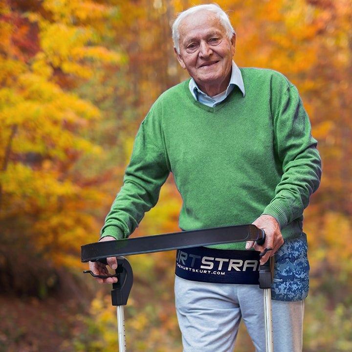 Senior man walking with his walker while wearing a large HurtSkurt® on his hip with a SkurtStrap