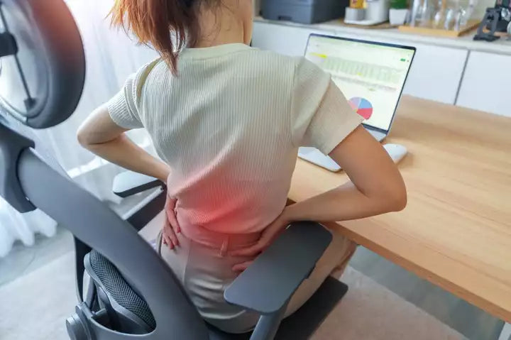 Woman having lower back pain while working